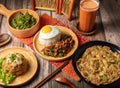 Fried Rice with Shrimp Paste, Tossed Chicken, beef, pork Rice with sunny egg, Baked Egg and Thai milk tea served in wooden dish Royalty Free Stock Photo