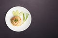 Fried rice with shrimp in round white dish isolated on black nature stone background. Thai Food concept Royalty Free Stock Photo