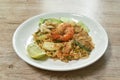 Fried rice shrimp and squid with pork in tom yum sauce topping slice cucumber couple lemon on plate