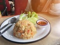 Fried rice with shrimp in Thai decorate the dish with green onion, cucumber, lettuce, chilli and lemon