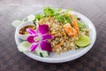 Fried rice with shrimp on the white ceramic dish decorated with orchid and hot spicy dipping sauce put on leather floor the grid p Royalty Free Stock Photo