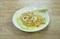 Fried rice squid and egg with slice cucumber couple lemon on plate