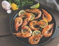 Fried roasted shrimps in frying pan with lemon greens parsley garlic