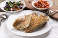 Fried rose fish fillet on a white plate