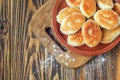 Fried russian pastry pirozhki on wooden background. Royalty Free Stock Photo
