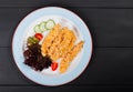 Fried salmon fillet with vegetables salad on black plate on dark background. Royalty Free Stock Photo