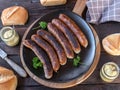 Fried sausage or Bratwurst with buns and mustard on wooden table Royalty Free Stock Photo