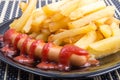 Fried sausage and french fries decorated with tomato sauce Royalty Free Stock Photo