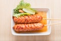 Fried sausage a grill on a stick in sauce. Royalty Free Stock Photo