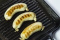 Fried sausages in a black frying pan with grill. Close-up. Royalty Free Stock Photo