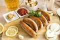 fried sausages on the Board, beer, ketchup, mustard, spices, crackers, lemon, onion, garlic Royalty Free Stock Photo