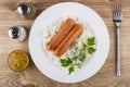 Fried sausages with boiled rice, bowl with mustard, salt, pepper Royalty Free Stock Photo