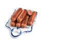 Fried sausages on a ceramic serving Board, white isolated background, close-up, horizontal view Royalty Free Stock Photo