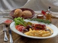 Fried sausages with French fries, salad and mushrooms Royalty Free Stock Photo