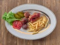 Fried sausages with French fries, salad and mushrooms Royalty Free Stock Photo