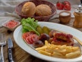 Fried sausages with French fries, salad and mushrooms Royalty Free Stock Photo