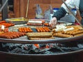 Fried sausages on the grill. German sausage swing grill at city market on holiday Royalty Free Stock Photo