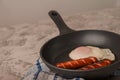 Fried sausages in a pan with scrambled eggs close-up and copy space. Boiled sausages and fried eggs breakfast in a frying pan Royalty Free Stock Photo