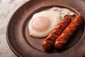 Fried sausages on a plate with scrambled eggs close-up and copy space. Boiled sausages and fried eggs for breakfast in a plate Royalty Free Stock Photo