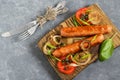 Fried sausages and vegetables on wooden plate Royalty Free Stock Photo