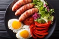 Fried sausages wrapped in bacon, eggs and fresh salad close-up. Royalty Free Stock Photo