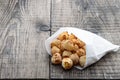 Fried savory mini cheese balls in paper bag on wooden table