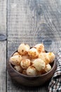 Fried savory mini cheese balls in wooden bowl on rustic table