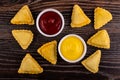 Fried savory pies, bowls with ketchup, mayonnaise on table. Top view