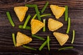 Fried savory pies, pieces of green onion on table. Top view