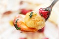 Fried scallop with raspberries on a fork