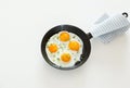 Fried scrambled eggs in a frying pan, bread and salt on a white background. Royalty Free Stock Photo