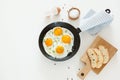 Fried scrambled eggs in a frying pan, bread and salt on a white background. Royalty Free Stock Photo