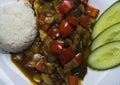 Fried sea bass fish in oil with sweet and sour sauce, vegetables and a portion of rice on a white plate Royalty Free Stock Photo