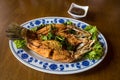 Fried sea bass fish in white plate with spicy and sweet sauce in Thai style .  crispy Thai style deep fried whole sea bass fish se Royalty Free Stock Photo