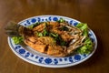 Fried sea bass fish in white plate with spicy and sweet sauce in Thai style .  crispy Thai style deep fried whole sea bass fish se Royalty Free Stock Photo