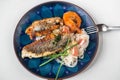 Fried sea bream fillet and shrimp with glass noodle on blue decorative plate on white Royalty Free Stock Photo