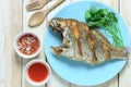 Fried sea fish in dish on wooden floor and Thai spice sauce.