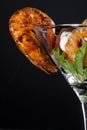 Fried shrimp hanging from a glass with a cocktail salad of green salad, tomato, cheese and toast