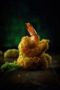 fried shrimp on wasabi paste on a dark background