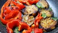 Fried sliced eggplants and sweet bell pepper with fresh basil leaves. Vegetable hot dish in frying pan Royalty Free Stock Photo