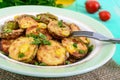 Fried slices of young zucchini with hot pepper, greens on a plate on a wooden background. Royalty Free Stock Photo