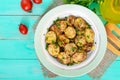 Fried slices of young zucchini with hot pepper, greens on a plate on a wooden background. Royalty Free Stock Photo