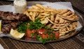 .Fried souvlaki with greek salad, potatoes and tzatziki sauce in plate Royalty Free Stock Photo