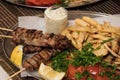 .Fried souvlaki with greek salad, potatoes and tzatziki sauce in plate Royalty Free Stock Photo