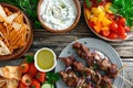 Fried souvlaki, greek salad and tzatziki on wooden table