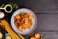 Fried Spaghetti or Fried Noodles Tomato sauce and prawns on a blue plate On a black wooden table top, top view Royalty Free Stock Photo