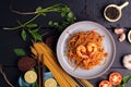 Fried Spaghetti or Fried Noodles Tomato sauce and prawns on a blue plate On a black wooden table top, top view Royalty Free Stock Photo