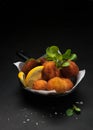 Fried Spanish bacalao croquettes in iron pan made with breaded salted codfish and served as traditional tapas or snacks. Dark Royalty Free Stock Photo