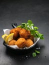 Fried Spanish bacalao croquettes in iron pan made with breaded salted codfish and served as traditional tapas or snacks. Dark Royalty Free Stock Photo