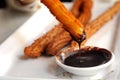 Fried Spanish Churros dipping to warm chocolate sauce Royalty Free Stock Photo